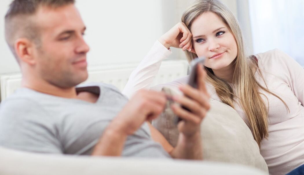 Frau schaut genervt zu ihrem Partner