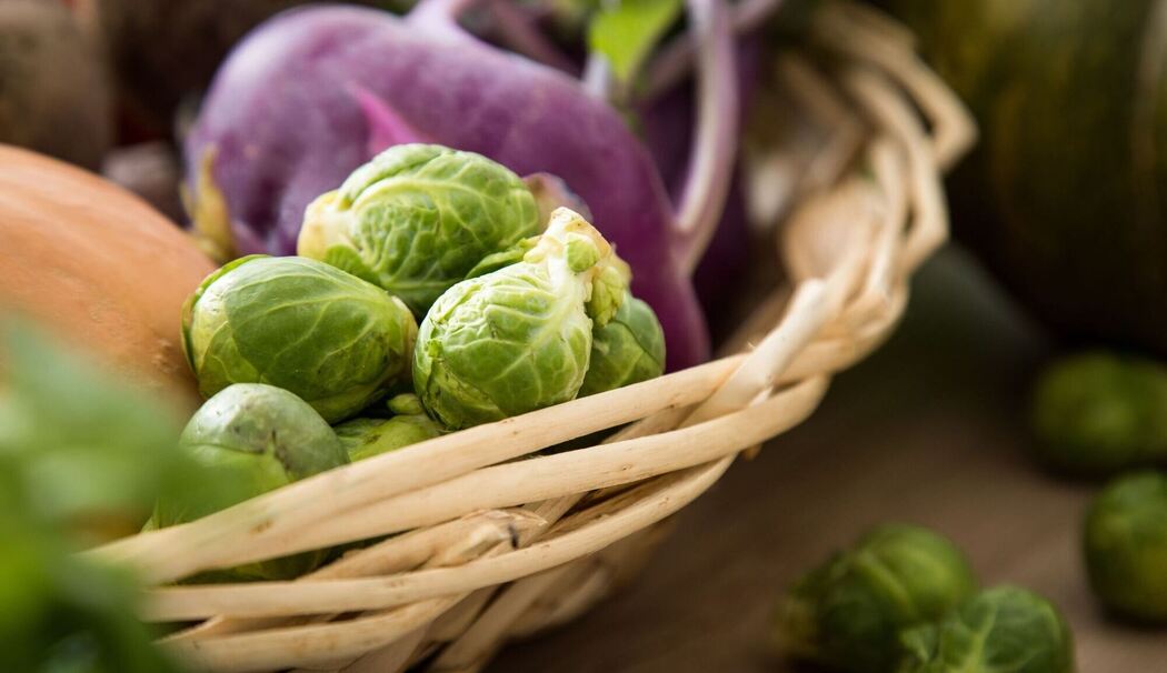 Rosenkohl und violetter Kohlrabi liegen in einem Korb