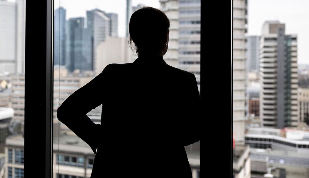 Frau schaut aus einem Bürofenster