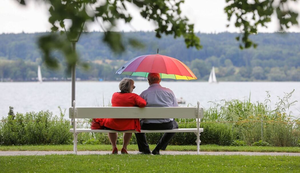 Renter sitzen mit einem Schirm am See