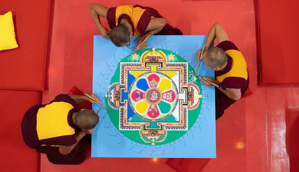 Tibetische Mönche streuen Sandmandala