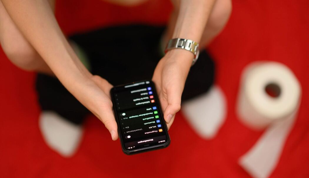 Mit Smartphone auf der Toilette