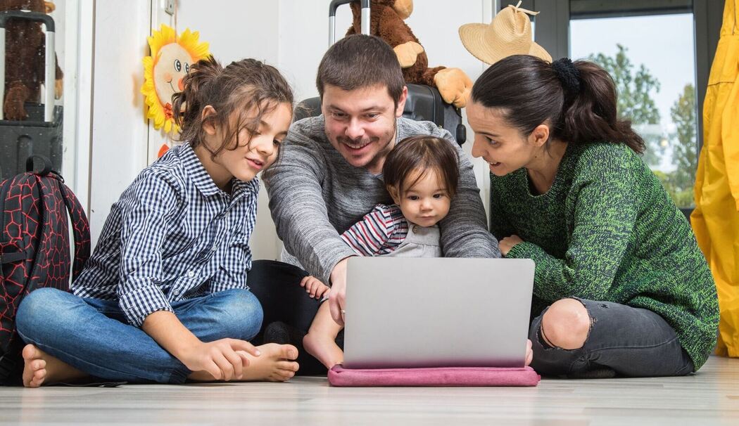Eine Familie plant ihren Urlaub am Laptop