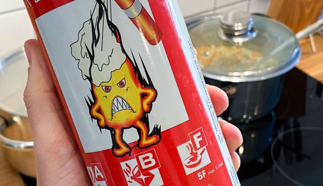 Mann hält ein Feuerlöschspray in der Hand