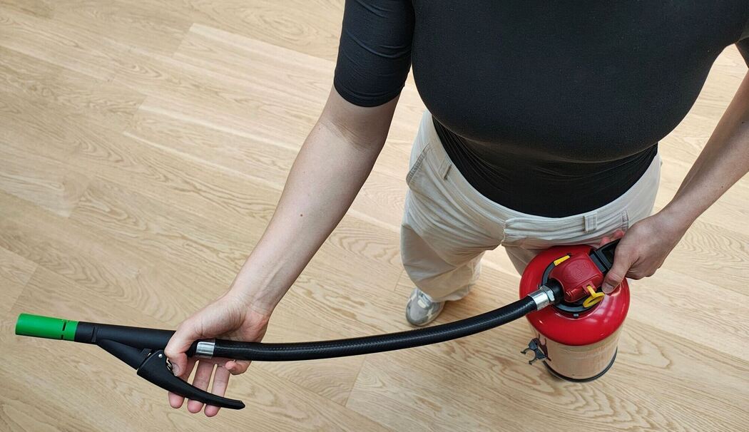 Eine Frau benutzt einen Feuerlöscher