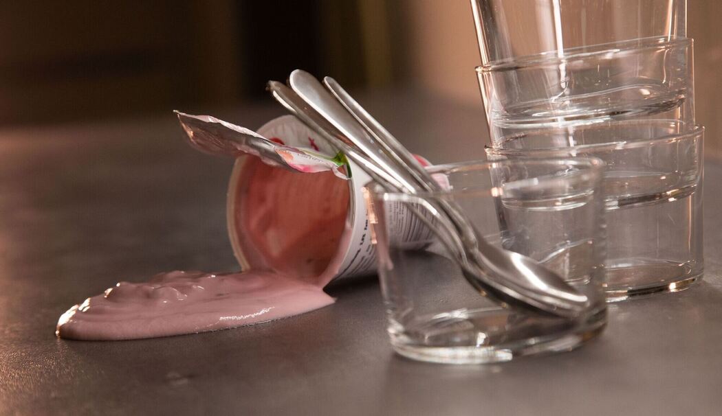 Joghurt fließt aus einem umgekippten Becher