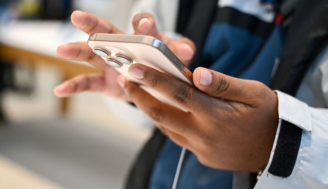 Ein Mann hält ein iPhone 16 in den Händen