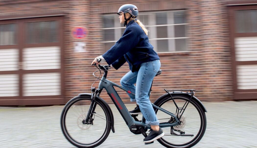 Eine junge Frau fährt auf einem E-Trekkingbike