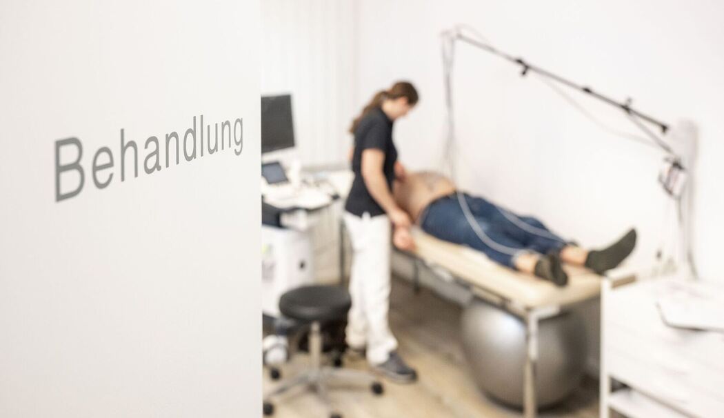 Sprechstundenhilfe bereitet Patienten auf Ruhe-EKG vor