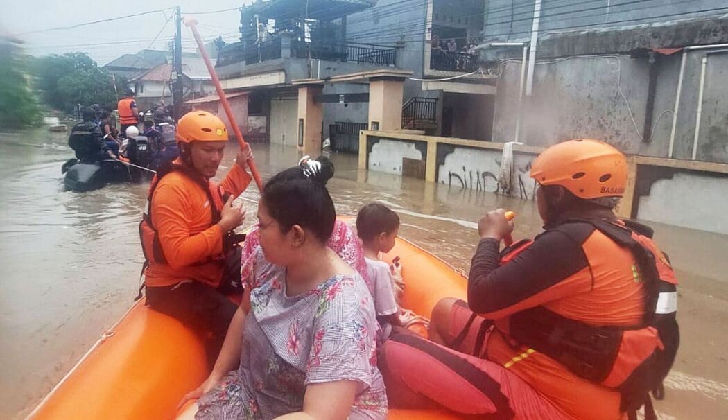 Retter beim Evakuieren bei Überflutungen auf Bali