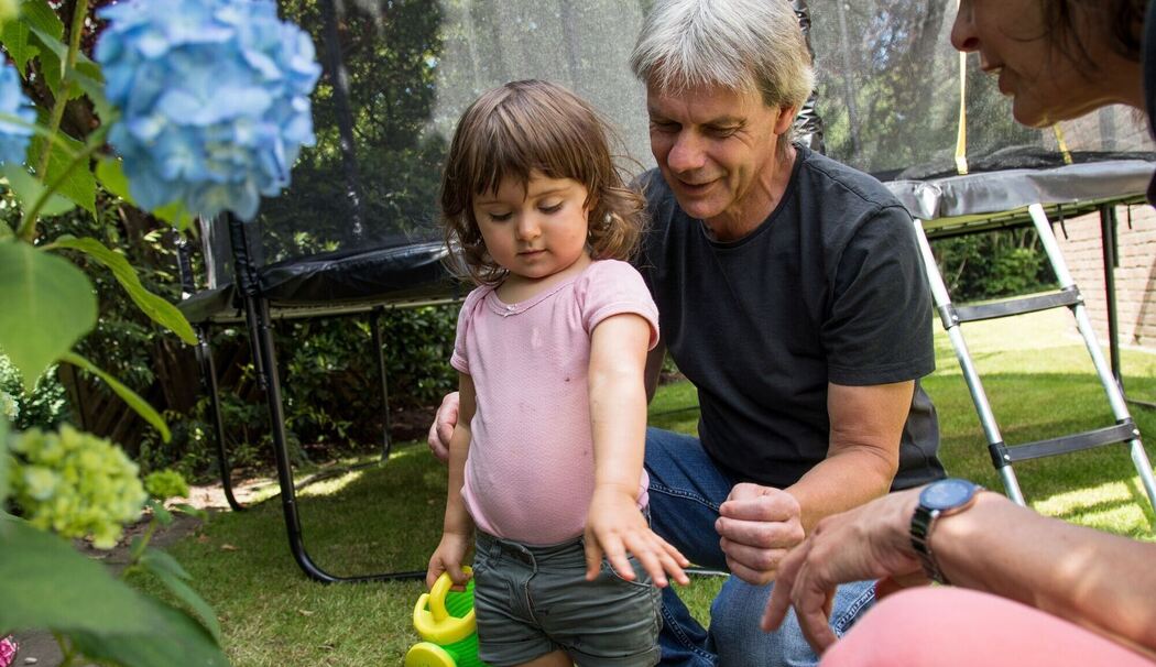 Großeltern spielen mit ihrer Enkelin im Garten