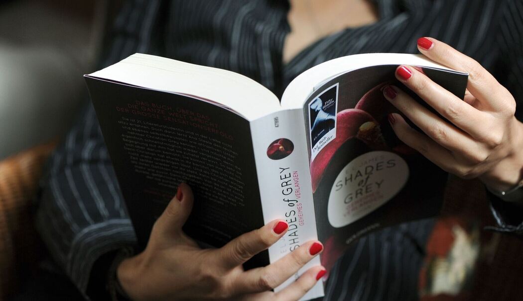 Eine Frau liest im Buch "Shades of Grey"
