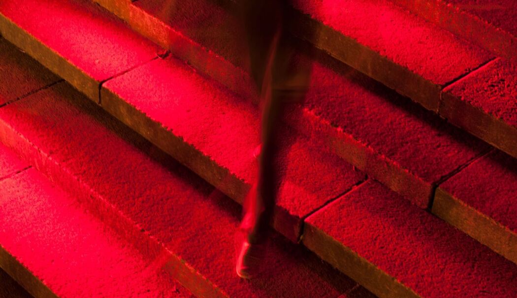 Männerbein in Anzug auf roter Treppe