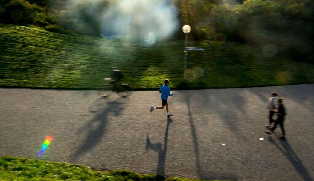 Ein Mann joggt durch den Olympia-Park in München
