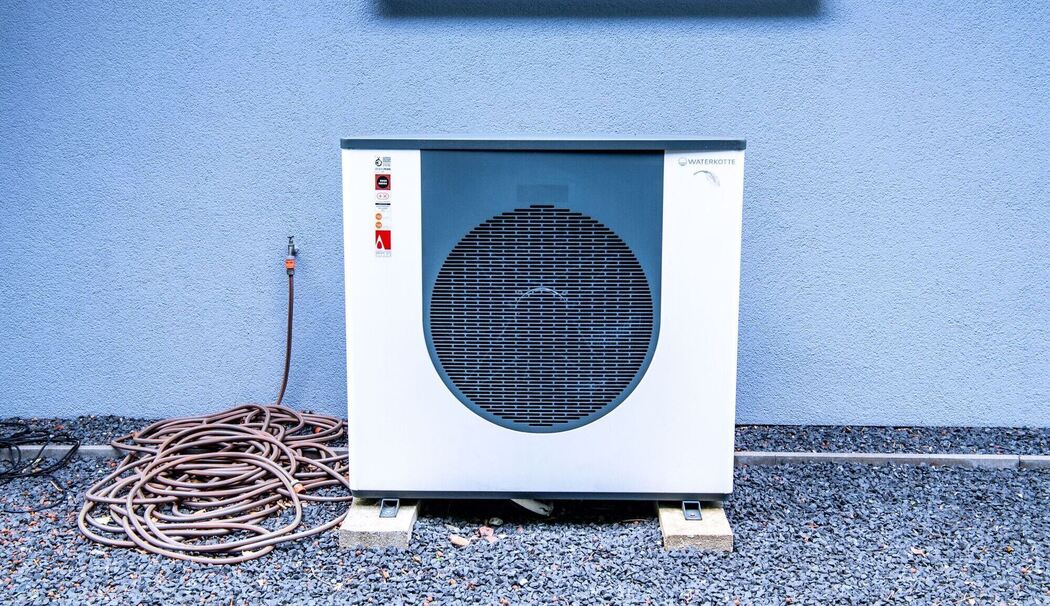 Eine Wärmepumpe vor einem Wohnhaus