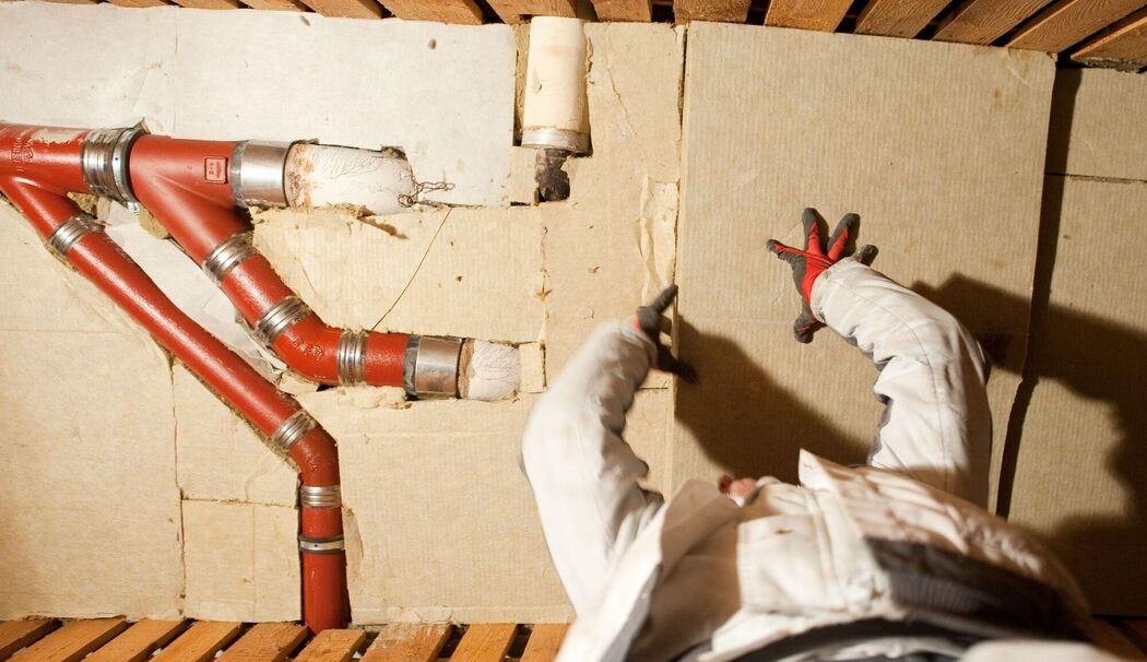Ein Mann dämmt eine Kellerdecke