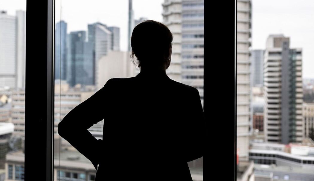 Frau schaut aus einem Bürofenster