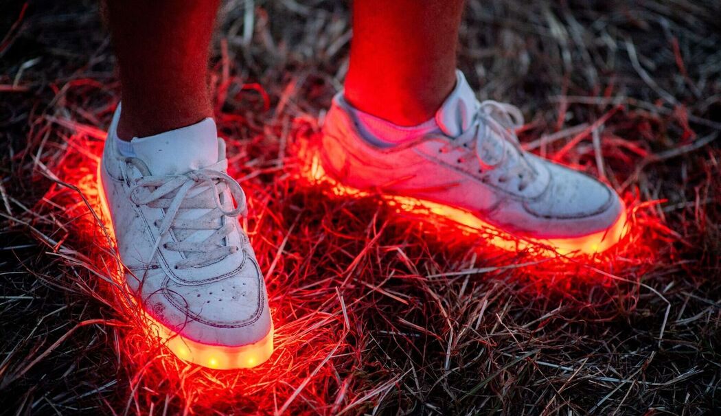 Ein Mann trägt ein paar rotleuchtende Schuhe