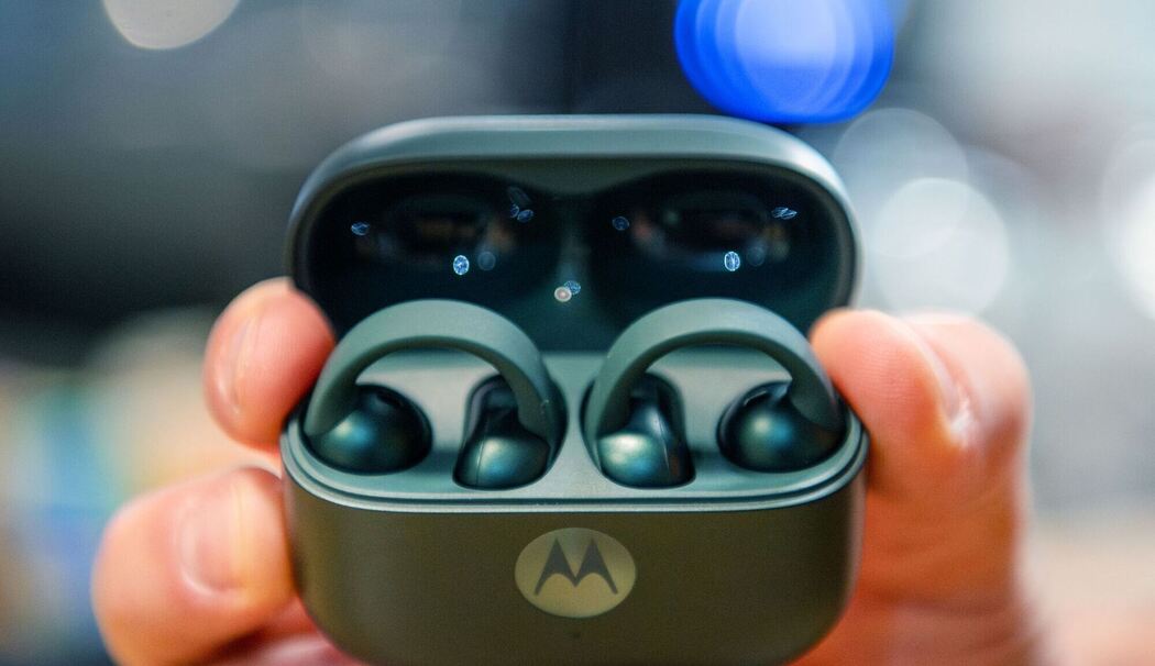 Mann hält ein Ladecase mit den Moto Buds Loop in der Hand