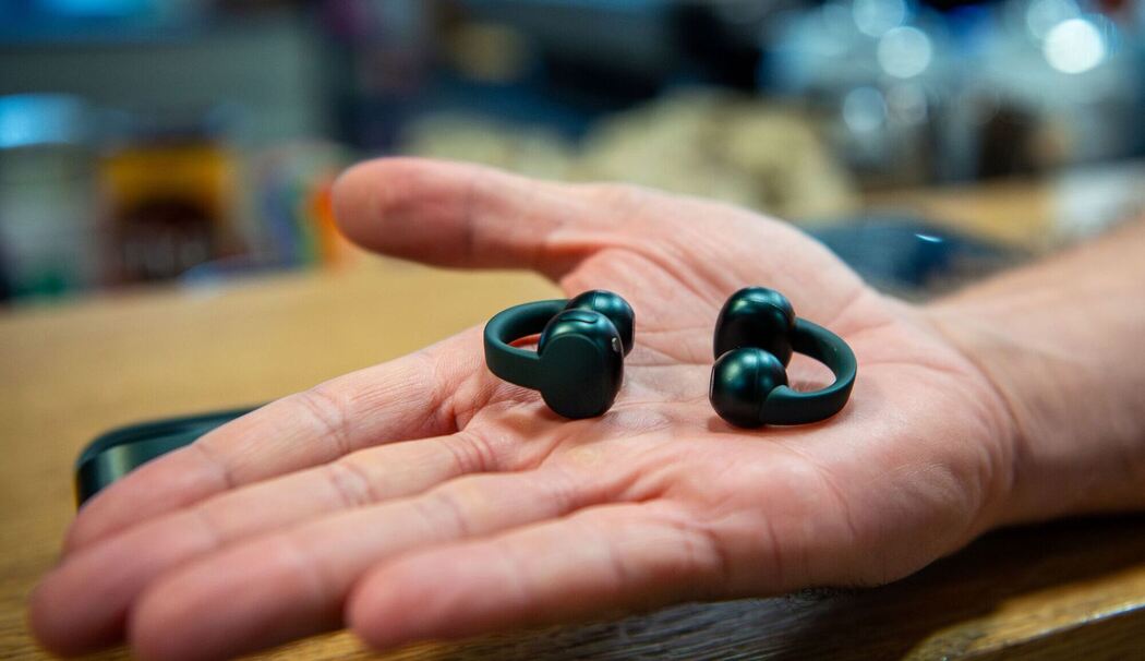 Ein Mann hält die Moto Buds Loop von Motorola in der Hand