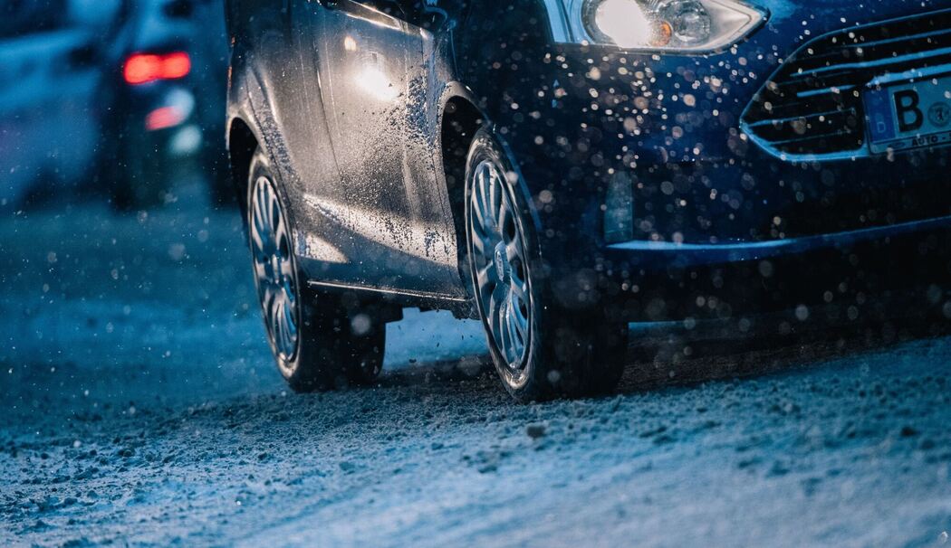 Ein Auto fährt zur dunklen Jahreszeit auf der Straße