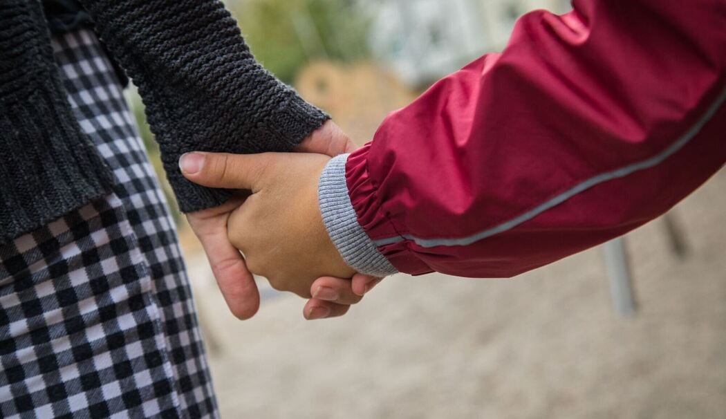 Eine Mutter hält die Hand ihres Kindes