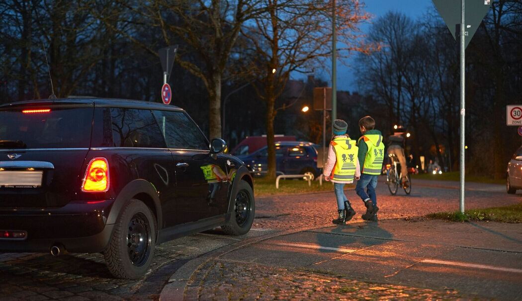 Kinder mit Warnwesten im Straßenverkehr