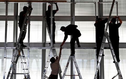 Silhouetten von Arbeitern, die eine Bühne abbauen