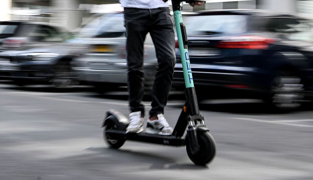 Ein Mann fährt mit einem E-Tretroller auf der Straße