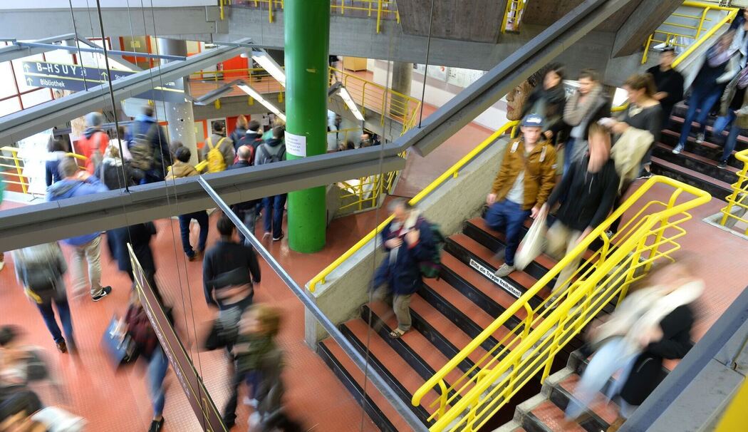 Studierende laufen durch das Treppenhaus einer Hochschule