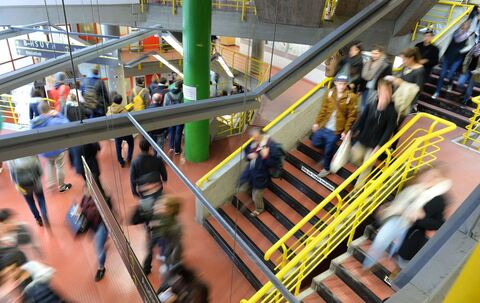 Studierende laufen durch das Treppenhaus einer Hochschule