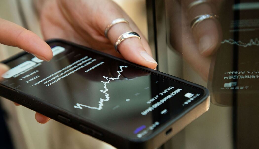 Eine Frau schaut auf dem Handy nach einem ETF Kurs