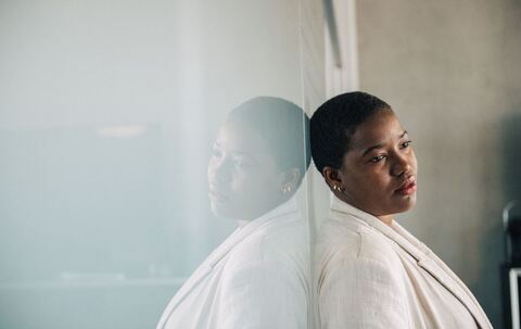 Eine Frau lehnt nachdenklich an einer Wand