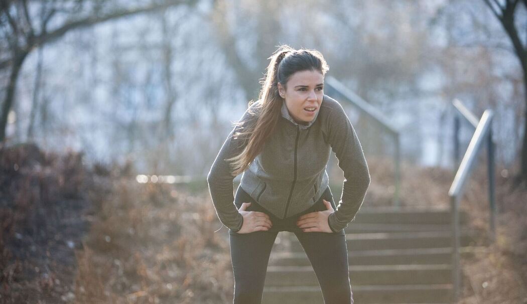 Frau macht während des Lauftrainings eine Pause