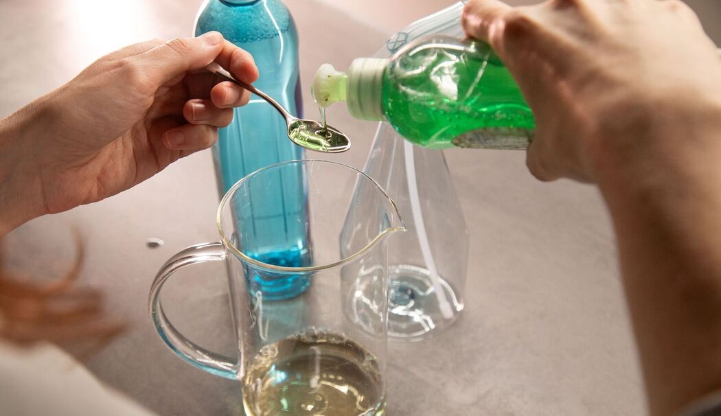 Mix aus Klarspüler, Wasser und Essig wird mit Spüli gemischt