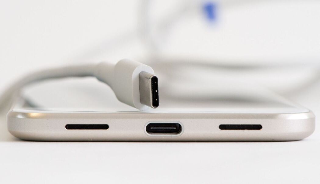 USB-C-Kabel und Ladebuchse an einem Smartphone