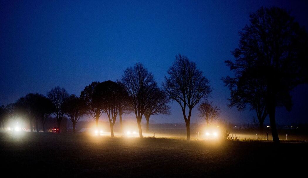 Autos fahren in der Abenddämmerung über eine Landstraße