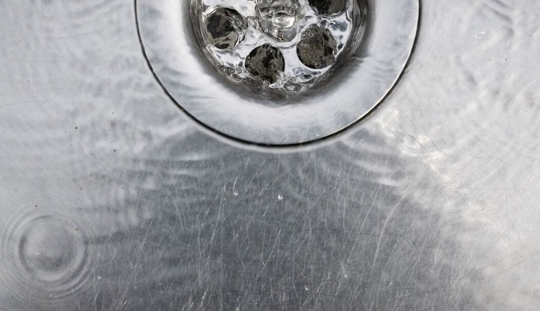 Wasser läuft in einen Abfluss im Spülbecken