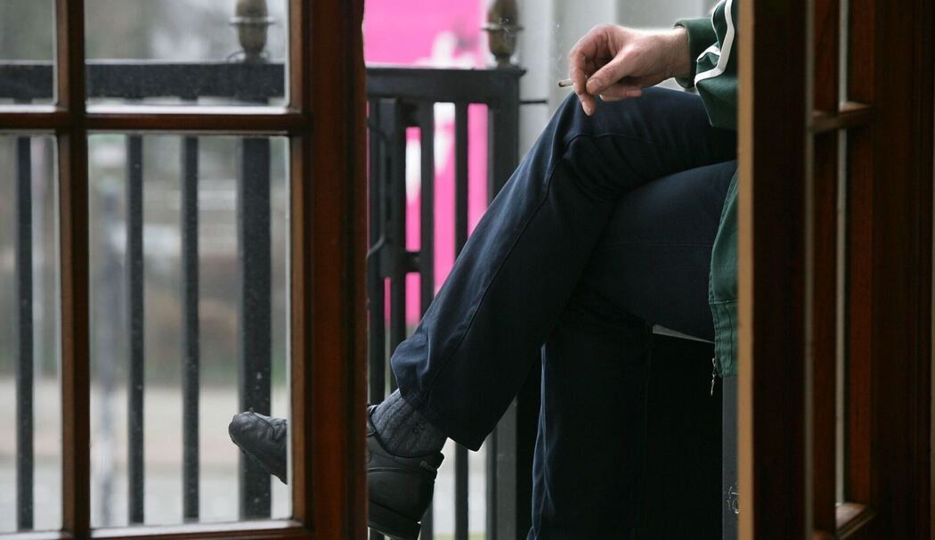 Ein Raucher auf einem Balkon