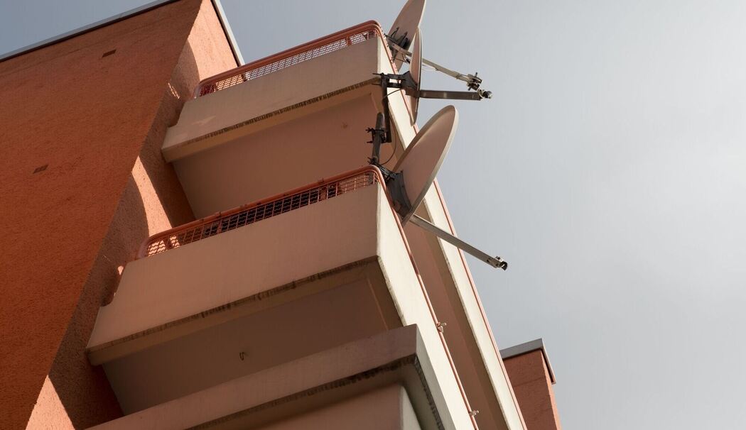 Satellitenschüsseln an einem Wohnhaus