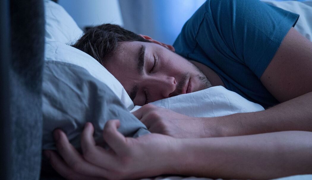 Mann schläft in einem Bett