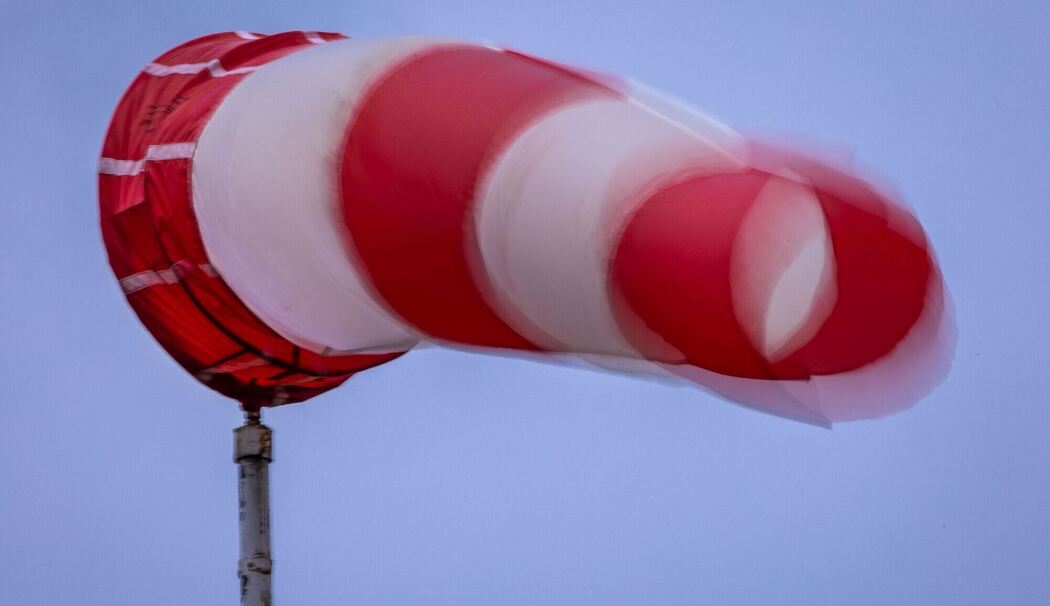 Windsack weht bei Regen und kräftigem Wind am Mast Windsack weht bei Regen und kräftigem Wind am Mast