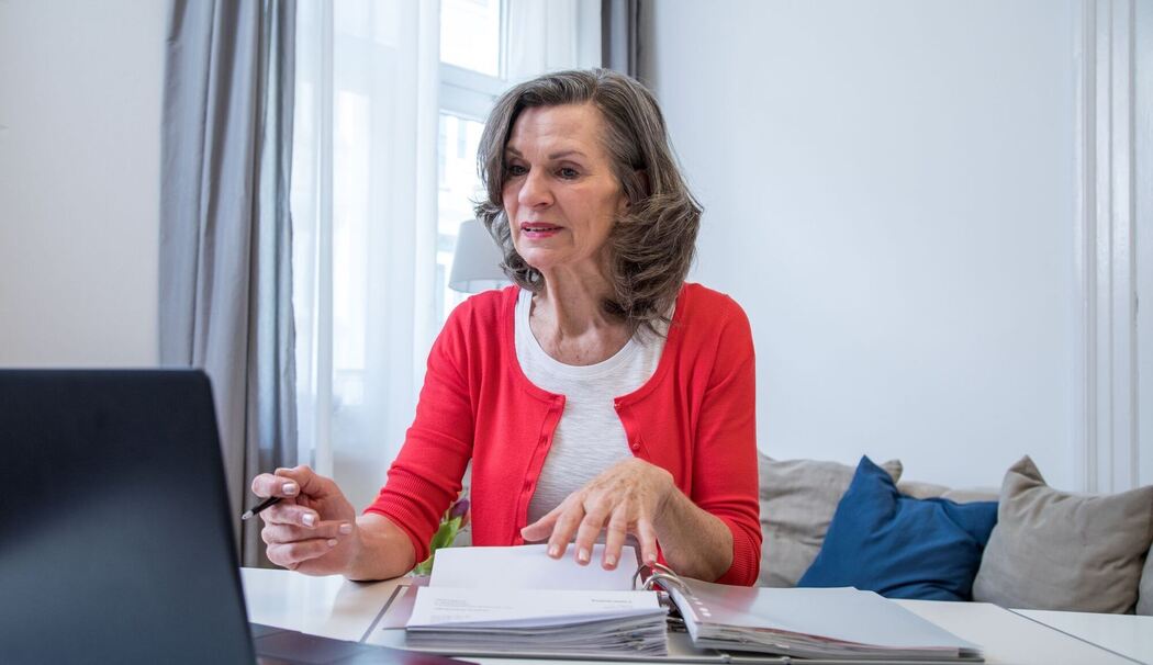 Eine ältere Frau arbeitet am Laptop. Eine ältere Frau arbeitet am Laptop.