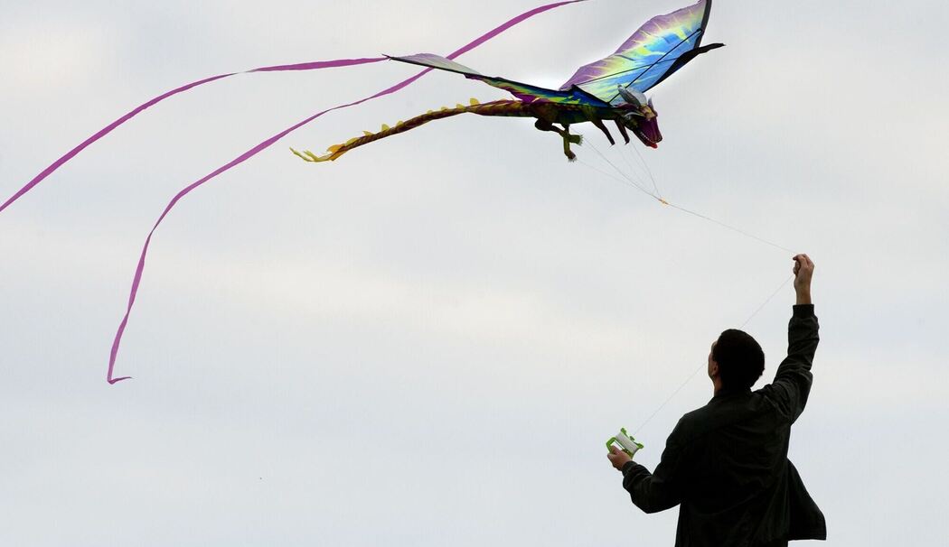 Mann lässt einen Drachen steigen Mann lässt einen Drachen steigen