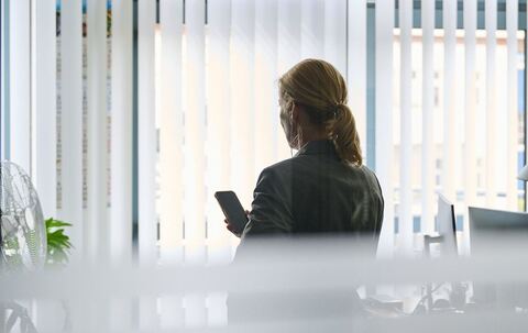 Frau steht im Büro und telefoniert mit einem Headset