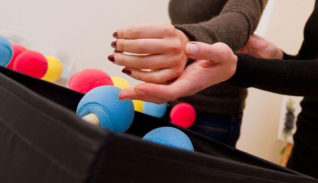 Eine Ergotherapeutin trainiert die Hand einer Patientin Eine Ergotherapeutin trainiert die Hand einer Patientin