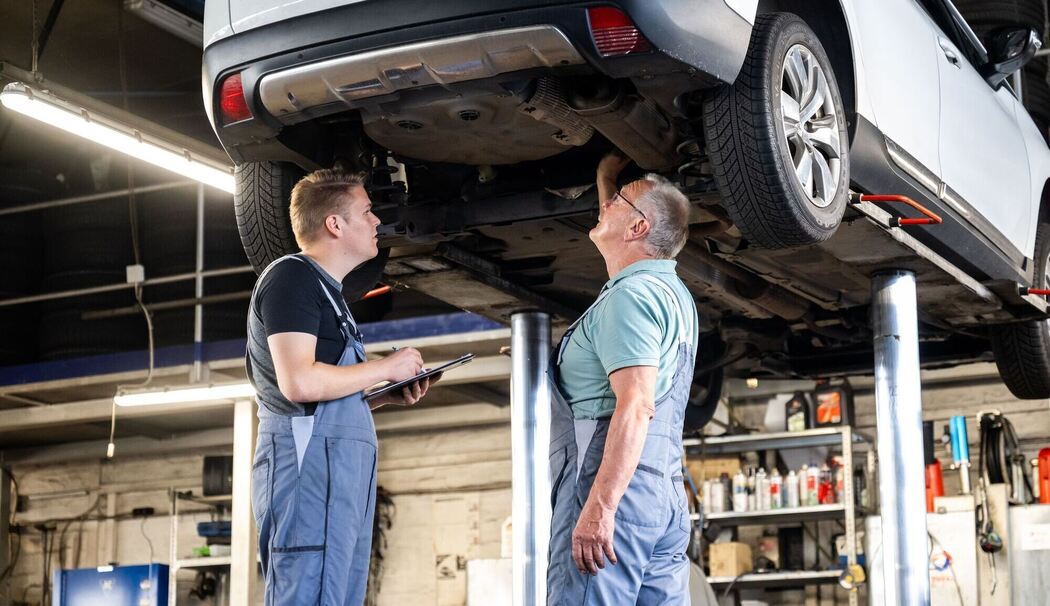 Zwei Männer arbeiten gemeinsam in einer Autowerkstatt