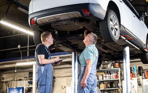 Zwei Männer arbeiten gemeinsam in einer Autowerkstatt