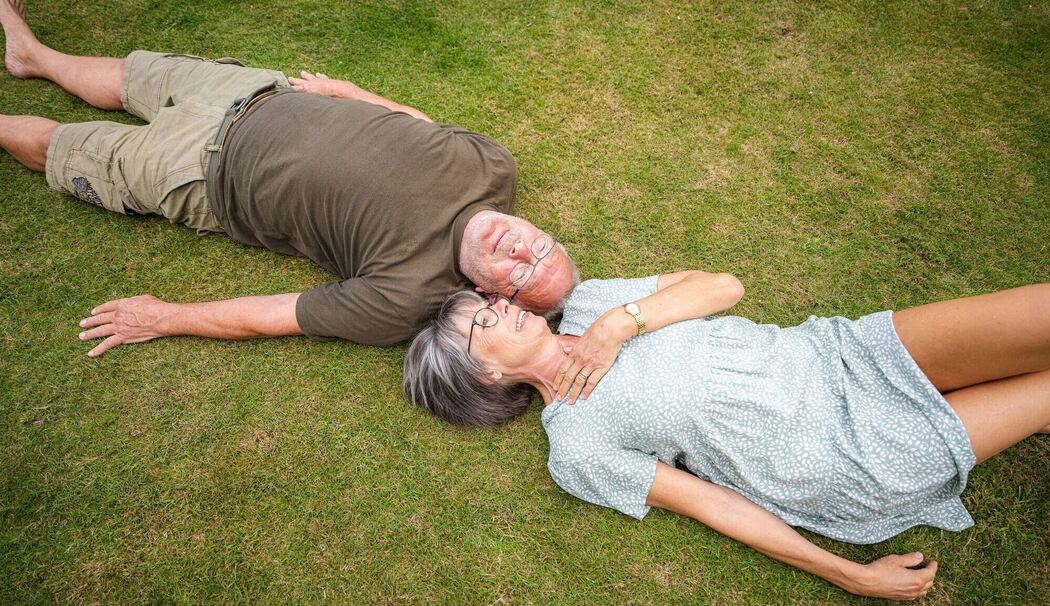 Ein älteres Paerchen liegt in einem Garten Ein älteres Paerchen liegt in einem Garten