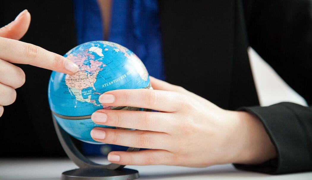 Eine Frau schaut auf einen kleinen Globus im Büro